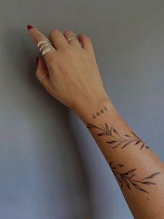 a woman's hand with a tattoo on her left wrist and the word love written in cursive writing