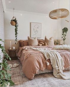 a bed with pillows and blankets on top of it in a bedroom next to plants