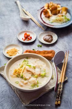 a bowl of chicken noodle soup with chopsticks and bread on the side