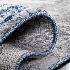 a close up view of a blue and white rug on the floor with an area rug underneath it