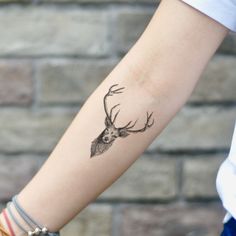 a woman's arm with a deer tattoo on it