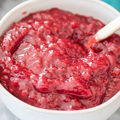 a white bowl filled with cranberry sauce on top of a table