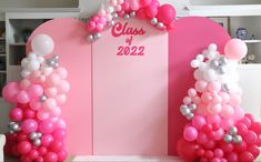 a pink and white backdrop with balloons on it