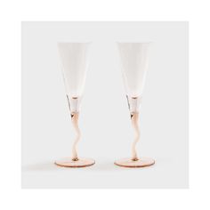 two champagne flutes with wooden bases on white background