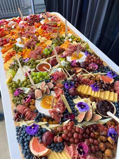 a table topped with lots of different types of fruit and cheese on top of each other