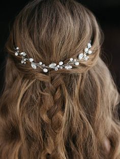 a woman with long hair wearing a white flowered headpiece on her head and braid