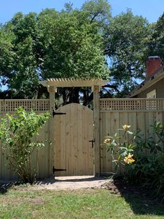 a wooden gate in the middle of a yard