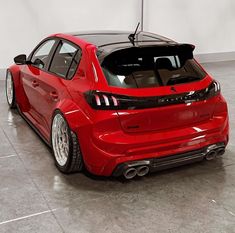 the rear end of a red car parked in a garage