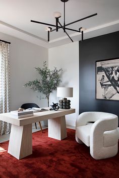 a modern living room with red carpeting and white furniture in the center, along with an art work on the wall