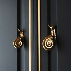 the door handle is gold and has two snails on it