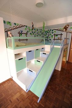 there is a bunk bed with a slide on the bottom and shelves below it that are built into the wall