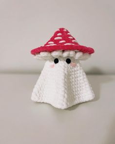 a crocheted toy with a red hat on it