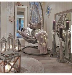 a living room filled with lots of furniture and candles in front of mirrors on the wall