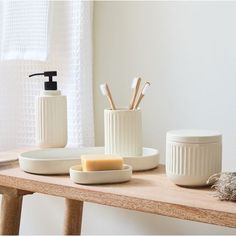 bathroom accessories displayed on wooden table in white room