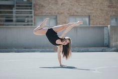 a woman doing a handstand on the ground