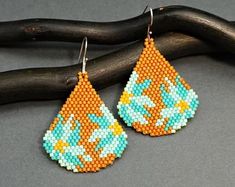 a pair of earrings made out of bead and plastic beads with the words earrings pattern on it