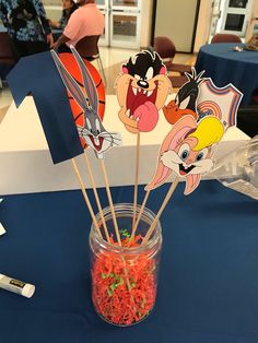 there are some cartoon characters in a jar on the table with toothbrushes and candy