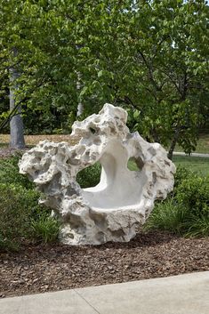 a white sculpture sitting in the middle of a park