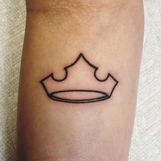 a small black crown tattoo on the right calf area, it looks like an outline