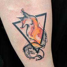 a tattoo on the leg of a person with a bird and triangle in front of it