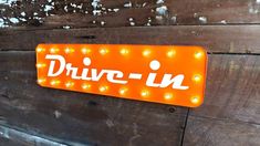 an orange sign that says drive - in on it's back side with lights