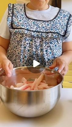 a woman is cooking food in a large pot