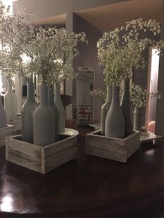 several vases with flowers in them sitting on a table