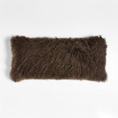 a brown furry pillow sitting on top of a white wall