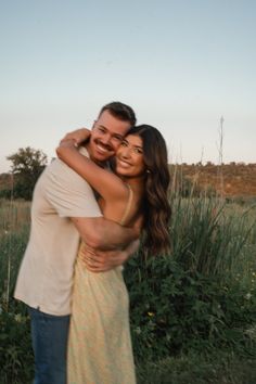 a man and woman hugging each other in a field