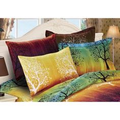 a bed with colorful comforters and pillows on it