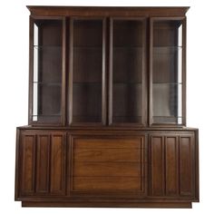 a wooden bookcase with glass doors on the top and bottom, against a white background