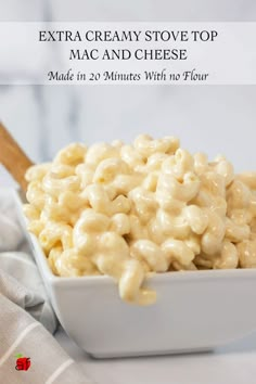 macaroni and cheese in a white bowl with a wooden spoon next to it