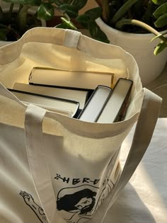 a book bag sitting on top of a white table next to a potted plant