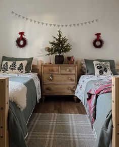 two beds in a room with christmas decorations on the wall