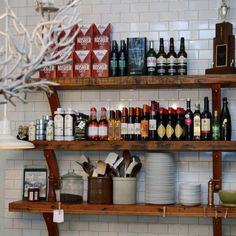 the shelves in the kitchen are filled with wine bottles