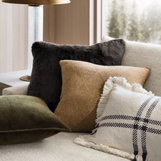 pillows on a couch in front of a window