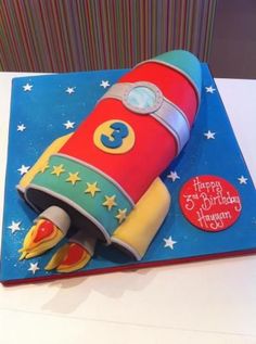 a birthday cake made to look like a rocket ship with the number 3 on it