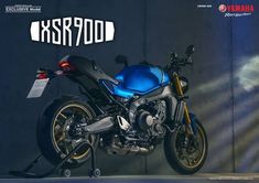 a blue and black motorcycle parked in front of a wall with the words kasperod on it