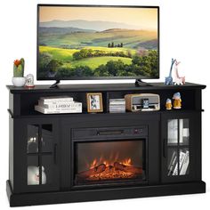 a flat screen tv sitting on top of a black entertainment center next to a fire place