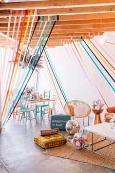 a living room filled with furniture and colorful streamers hanging from the ceiling above it