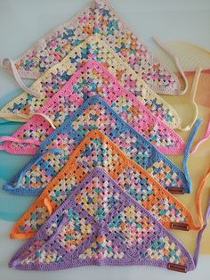 four crocheted purses sitting next to each other on top of a table