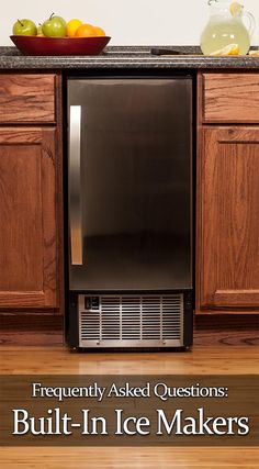 a black refrigerator freezer sitting on top of a kitchen counter next to wooden cabinets