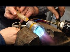 two men working on an object that looks like a machine with light coming out of it