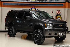 a black truck is parked in front of a gas station sign with the words,