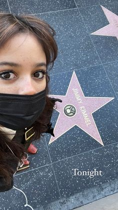 a woman wearing a face mask on the hollywood walk of fame