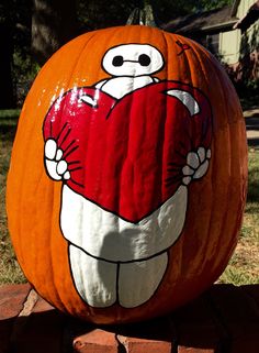 a large pumpkin with an image of a heart on it's face and arms