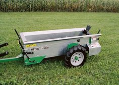 a green and silver wagon sitting in the grass