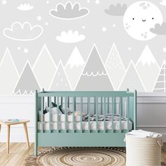 a baby's room with mountains and clouds painted on the wall