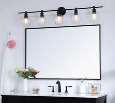 a bathroom vanity with a large mirror above it and three lights on the wall next to it