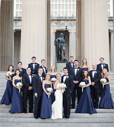 a large group of people in formal wear posing for a photo on the steps of a building